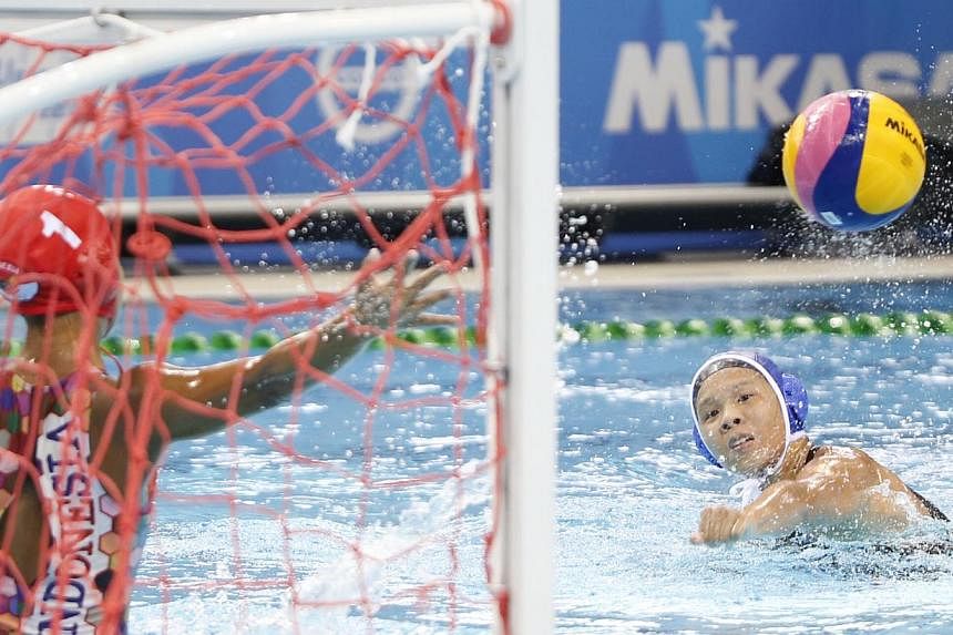 Singapore's Loke En Yuan (right) scores a goal against Indonesia in the women's water polo round robin match 1 during the 28th SEA Games at the OCBC Aquatics Centre on June 10, 2015. -- ST PHOTO: KEVIN LIM