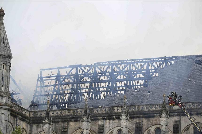 French firefighters try to extinguish the fire that damaged the roof of the Saint-Donatien Basilica in Nantes, western France on June 15, 2015. -- PHOTO: REUTERS
