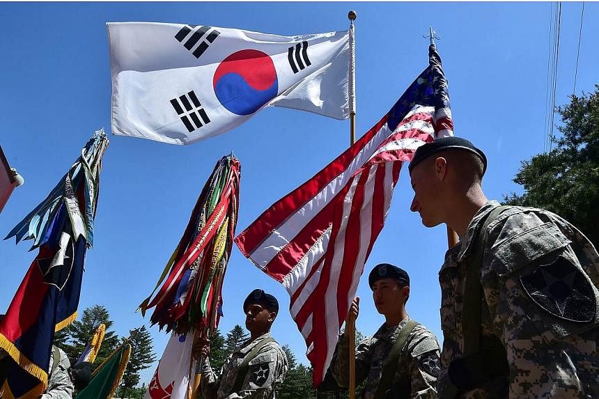 US soldiers hold the flags of South Korea (top) and the US (right) before a South Korea-US Combined Division activation ceremony at a US Army base in Uijeongbu, north of Seoul, on June 3, 2015.&nbsp;North Korea said on Monday, June 15, that it is rea