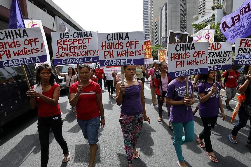 Filipinos display placards in protest over territorial disputes in the South China Sea during National Independence Day celebrations, in front of the Chinese consular office in Makati city, south of Manila, the Philippines, on June 12. -- PHOTO: EPA&