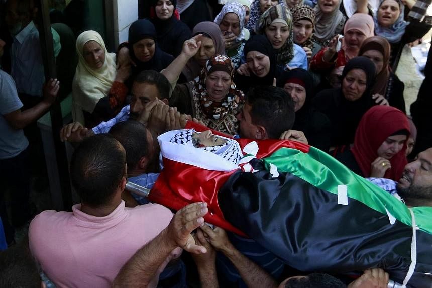 Palestinians carry the body of 21-year-old Abdallah Ghanayem, during his funeral in the west bank village of Qafr Malik near the West Bank city of Ramallah on Sunday. According to Palestinian medical sources, Israeli soldiers killed Ghanayem by hitti
