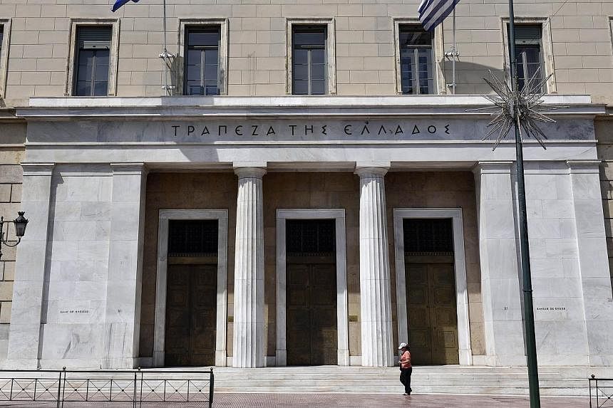 A woman walking past Bank of Greece headquarters in central Athens on June 15, 2015. US stocks retreated, with the Standard &amp; Poor's 500 Index slipping below its average price during the past 100 days, after weekend negotiations between Greece an