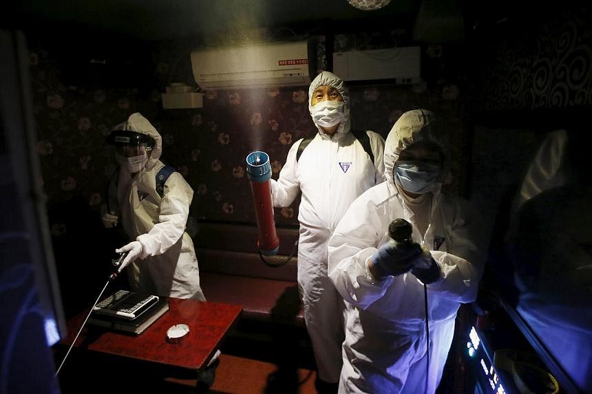 Workers disinfecting a karaoke establishment in Seoul, South Korea on June 16, 2015. Two South Korean hospitals are conducting experimental treatment on MERS patients, injecting them with blood plasma from recovering patients. -- PHOTO: REUTERS&nbsp;