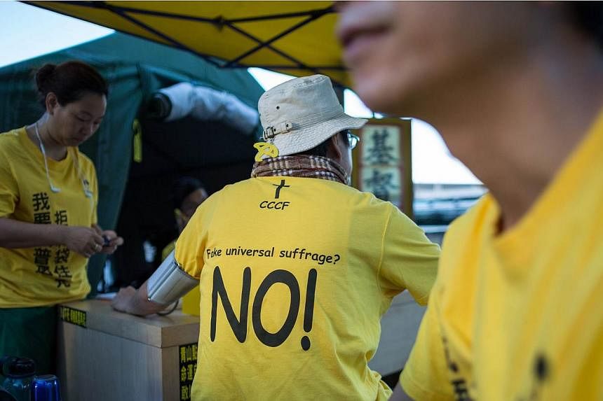 A protester wears a t-shirt against "fake universal suffrage" in a makeshift tent outside the Legislative Council in Hong Kong, China, on June 15, 2015. Hong Kong's Legislative Council (LegCo) will this week debate and vote on a bill on electoral ref