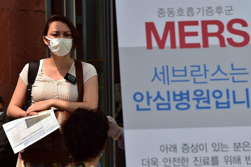 A woman wearing a face mask stands at a special clinic where patients with respiratory issues can be treated in an isolated space to prevent possible spread to other patients, at Severance Hospital in Seoul on June 16, 2015.&nbsp;A 65-year-old German