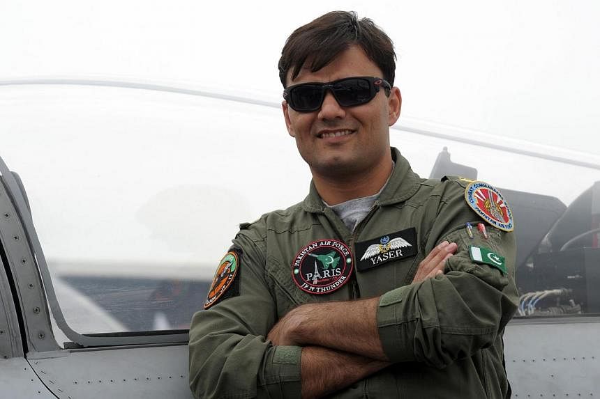 Pakistan Air Force Squadron Leader Yaser Mudasser poses in front Pakistan's JF 17 Thunder cockpit on the tarmac of the International Paris Airshow at Le Bourget on Monday. -- PHOTO: AFP