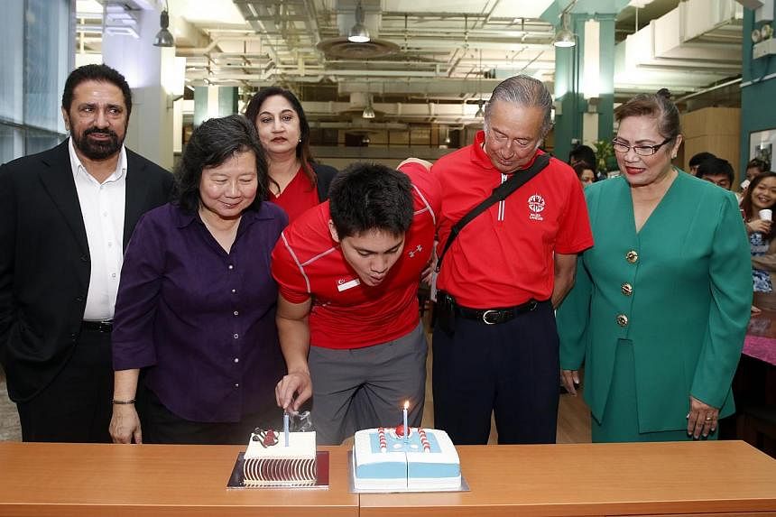 Joseph Schooling gets a birthday surprise in the news room with cakes from The Straits Times and the Eurasian Association. -- ST PHOTO: KEVIN LIM