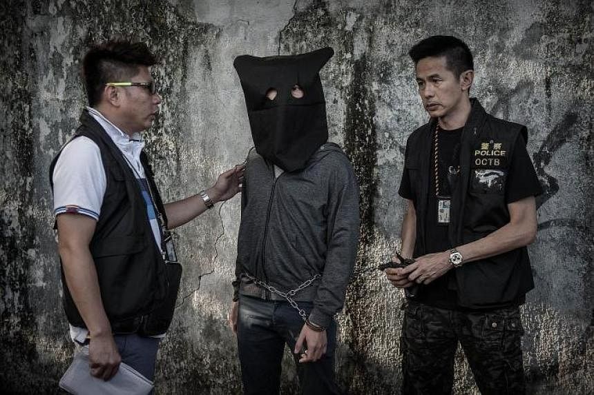 Hong Kong police with a suspect during a crime reconstruction yesterday, a day after 10 people were held on suspicion of making explosives ahead of a vote on a controversial political reform package.