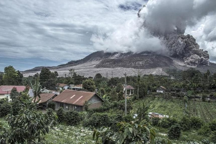 Mount Sinabung spewing ash, as seen from the nearest village in Karo district, North Sumatra province, yesterday. The volcano rumbled back to life in 2013, after a period of inactivity, and erupted violently over the weekend.