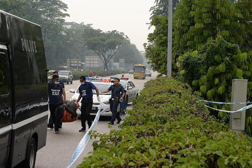 Police removing the body found in the vegetation by the Bukit Timah Expressway yesterday.