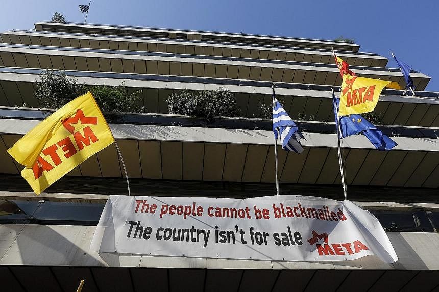 A banner hung up at the EU offices in Athens during a protest. Unless Greece settles its differences with the rest of Europe, it will run out of money to make a $2.4 billion debt repayment to the IMF at the end of this month.
