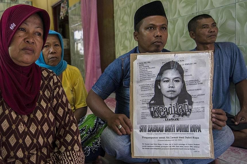 Family members of Indonesian maid Siti Zainab displaying a poster bearing her portrait. Siti was beheaded in April after being convicted of murder. President Joko Widodo announced last month that Indonesia would stop sending domestic workers to 21 Mi