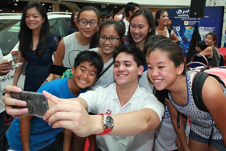 Singapore swim star Joseph Schooling takes a "wefie" with his fans at the launch of the Fina World Junior Championships in Singapore. The 20-year-old, who won nine golds at the just-concluded SEA Games, is the local ambassador for the Aug 25-30 event