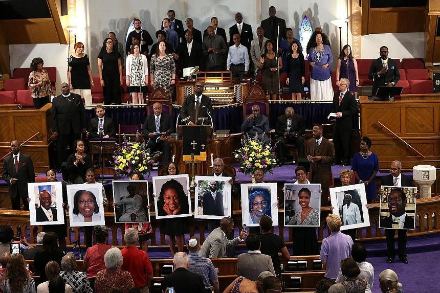 Photographs of the nine victims killed at the Emanuel African Methodist Episcopal Church in Charleston, South Carolina, are held up during a prayer vigil at the Metropolitan AME Church on Friday in Washington, DC.