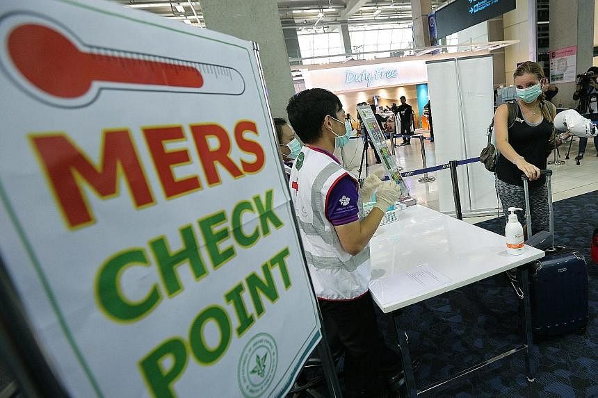 Passengers passing through a Mers health checkpoint at Bangkok's Suvarnabhumi airport on Sunday. Thermal scanners have been set up to screen visitors from the seven affected nations.