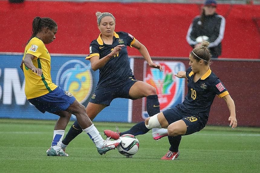Australia forward and scorer Kyah Simon (centre) and midfielder Katrina Gorry combining to stop Brazil midfielder Formiga during the game.