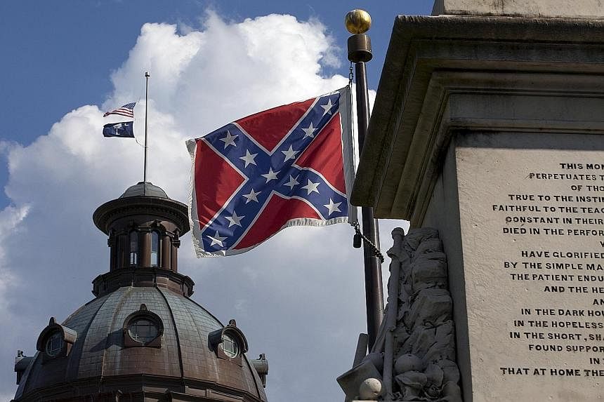 The Confederate battle flag (right) on the grounds of the South Carolina State House against the backdrop of the US flag and South Carolina state flag flying at half mast in the wake of the Charleston murders last week.