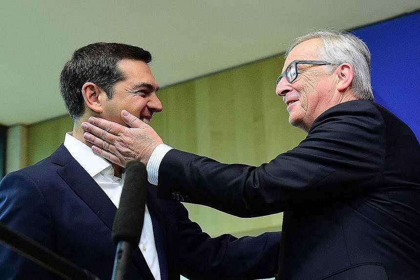 European Commission president Jean-Claude Juncker (right) greeting Greek PM Alexis Tsipras with a playful slap. Mr Juncker warned that a deal "was not there yet". Officials say there had been confusion overnight with Greece apparently initially sendi