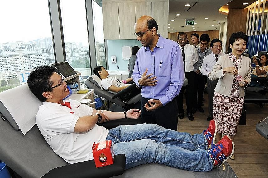 Deputy Prime Minister Tharman Shanmugaratnam, accompanied by Minister in the Prime Minister's Office Grace Fu, meeting blood donors at the opening of Bloodbank@Westgate Tower yesterday.