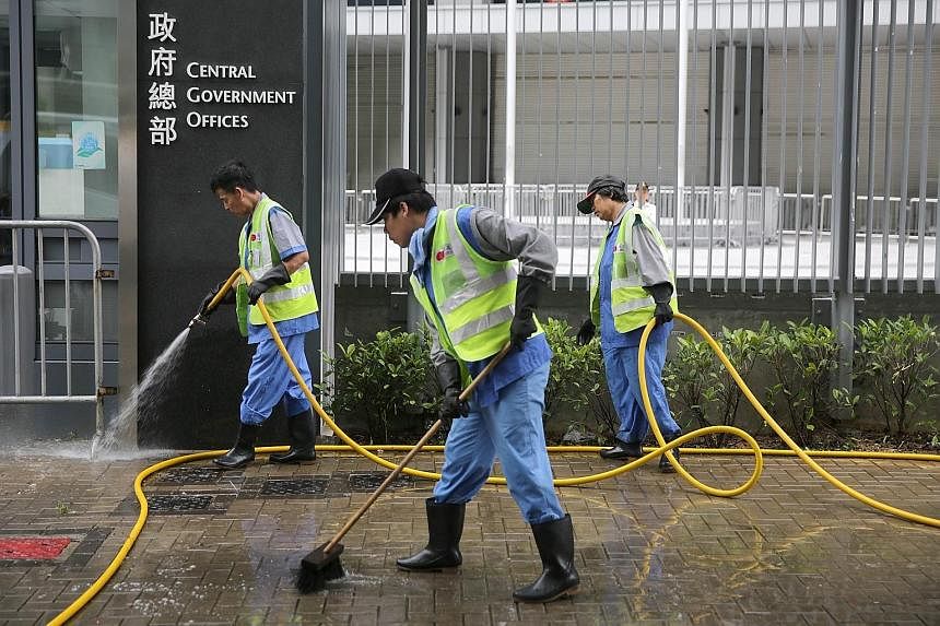 Workers washing the sidewalk after the clearance of the last pro-democracy site in Hong Kong. A ruling from Beijing sparked off the public protests over how Hong Kong chooses its next leader in 2017.