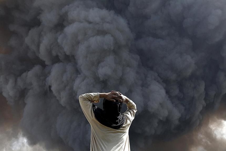 A villager (above) in Karo regency, North Sumatra province, watching the volcanic ash clouds caused by Mount Sinabung's eruption yesterday. The volcano, which began erupting violently two weeks ago, continued to spew lava (below, left) and hot ash. R