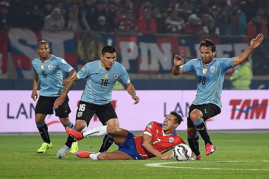 (Above) Copa holders Uruguay suffered a setback when Edinson Cavani, who flicked a hand into Gonzalo Jara's face, was sent off. (Left) It was a bruising match for Chile and Arsenal star Alexis Sanchez (on the ground), who bore the brunt of some tough