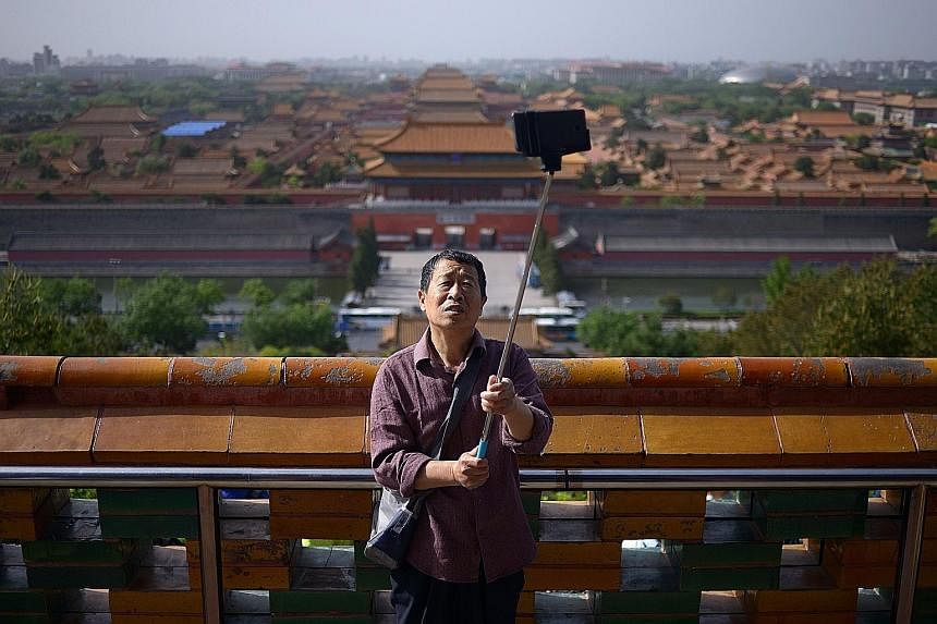 A man taking a selfie at a park near the Forbidden City in Beijing. Chinese officials are finalising plans to move Beijing's municipal government, including tens of thousands of civil servants, to a satellite town, leaving the core part of the capita