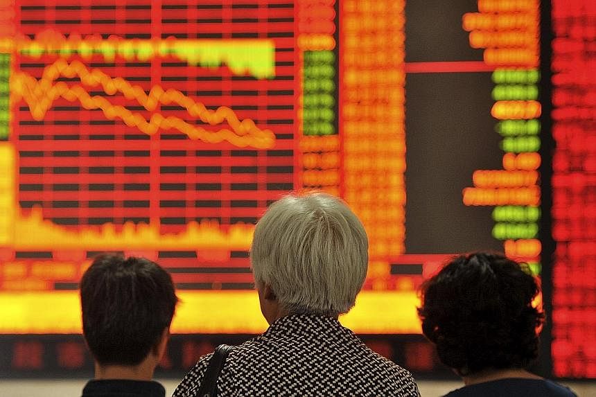 Investors studying an electronic board showing stock information yesterday at a brokerage house in Fuyang, Anhui province. China stocks yesterday posted some of their worst losses in seven years.
