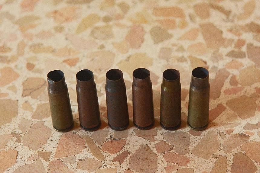 Empty bullet casings collected by a child. Gun violence and stabbings are common occurrences in and around the camp.