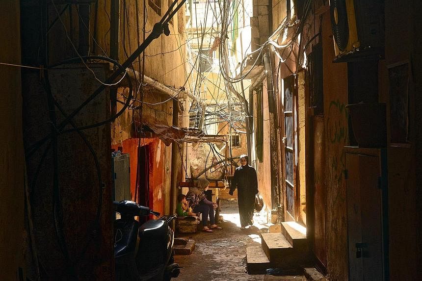 A typical scene in a back alley in the camp, with water hoses and electrical wires hanging haphazardly from buildings. Piped water is salty and potable water has to be purchased. This part of Beirut suffers from daily power cuts.