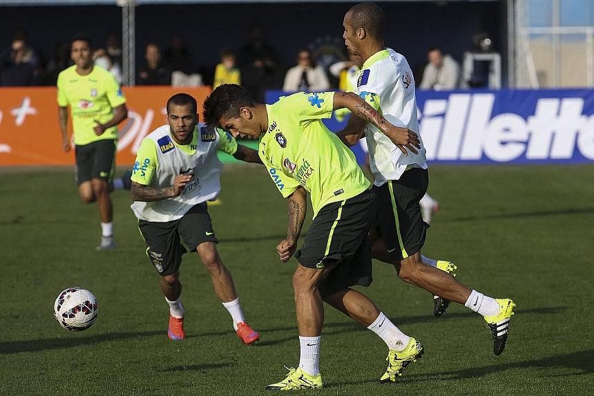Brazil's Liverpool-bound forward Roberto Firmino losing the ball under the challenge of his team-mate during their training session on Wednesday.