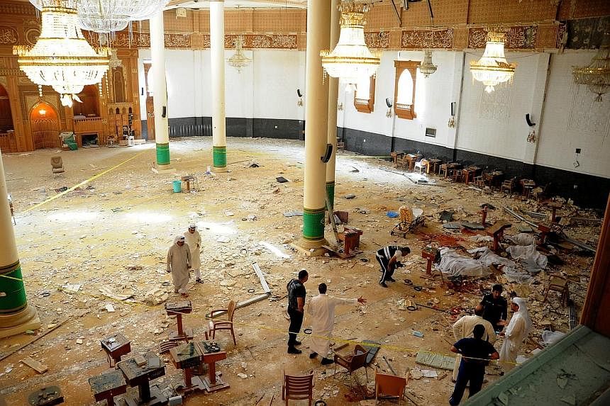 Medics and security officials inside the Al-Imam Al-Sadiq mosque in Kuwait City where a suicide bomb blast occurred yesterday.