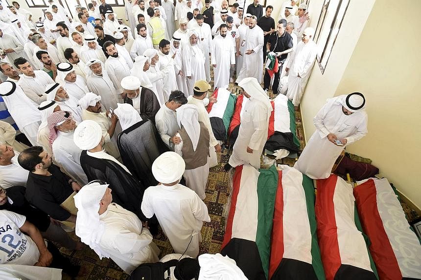 Kuwaiti flags are draped over the bodies of victims of last Friday's bombing, which killed 27 and injured at least 200 people.