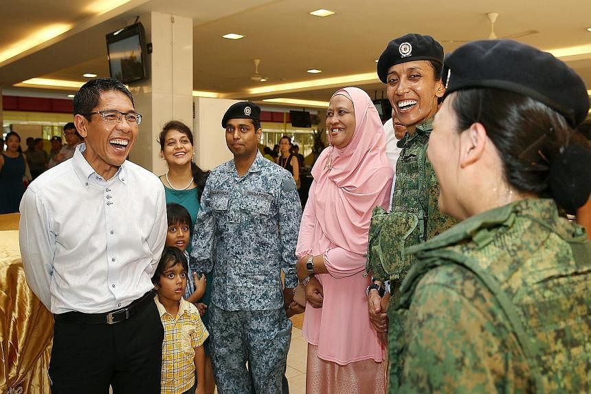 Military volunteer Siti Khairunessa Abdul Kadir with her mother Rosimah Salam (in pink) and fellow volunteer Neo Li Fang (back to camera) yesterday.
