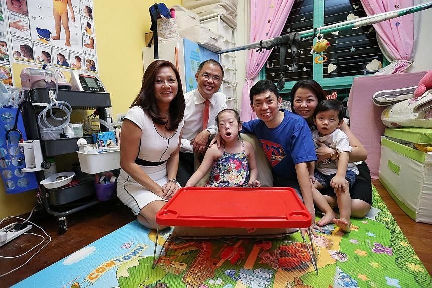 Six-year-old Chloe and her brother Cayden with their parents Kenneth and Patricia Mah. With them are the family's financial services consultants from AIA - Mr Tommy Tay and Ms Elaine Yeo (both on the left).