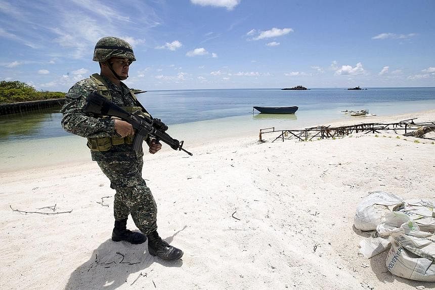 A Filipino soldier patrolling the shore of Thitu Island. The airstrip on the island has deteriorated, but the Philippine government has halted repair works on it due to its pending suit at The Hague.