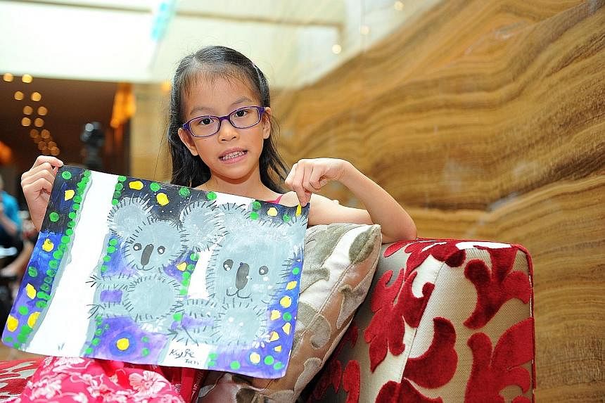 Kylie Tan, seven, with the picture she drew in celebration of Singapore's 50th year of ties with Australia, and presented to Mr Tony Abbott at the Grand Hyatt hotel yesterday.