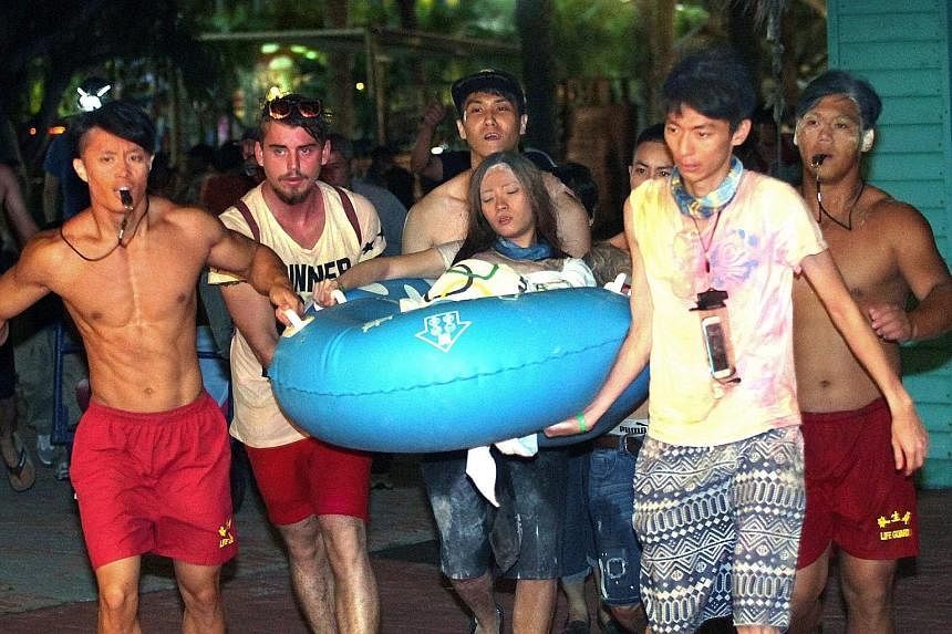 Lifeguards carrying a woman suffering from facial burns to an ambulance at the Formosa Fun Coast water park in New Taipei City, northern Taiwan, on Saturday.