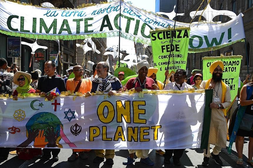 Activists displaying banners calling for action against world poverty, climate change and other environmental issues as they arrive at St Peter's Square prior to Pope Francis' Sunday blessing and message. The activists wanted to thank the Pope for hi