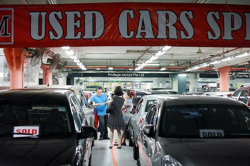 Second-hand car dealers such as those in Turf City (above) are seeing better business as motorists turn to older cars while waiting for COE prices to fall.