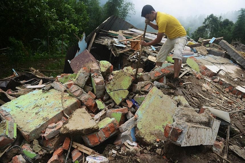A man searching for the bodies of those killed in a landslide at Tingling village, near Mirik, some 60km from Siliguri, yesterday. Landslides triggered by heavy rain have killed at least 21 people across India's famed tea-growing region of Darjeeling