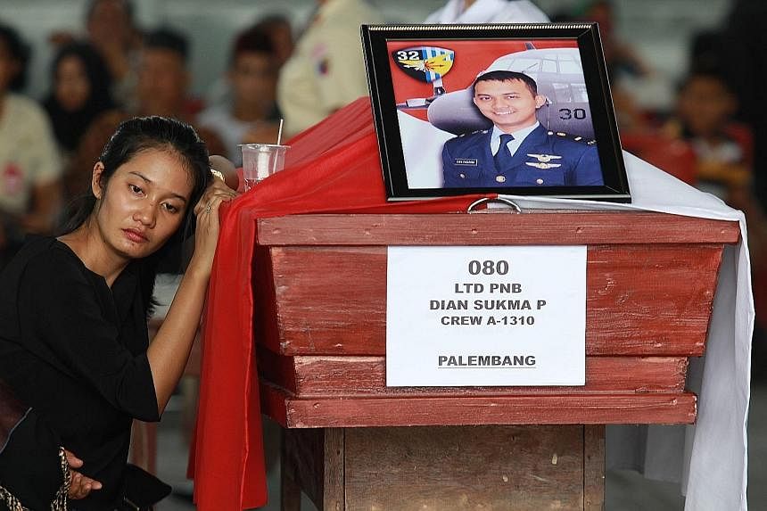 (Above) A relative of a plane crash victim grieves at a military airbase in Medan. Officials said there were 122 people on the flight, more than the 113 initially reported. Most were servicemen and their families. (Left, above) Indonesian President J