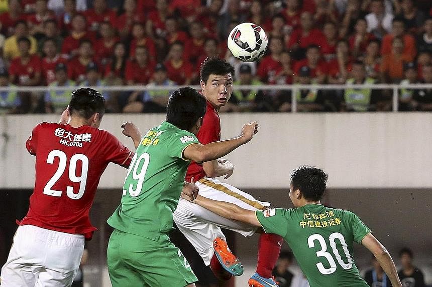 Football team Guangzhou Evergrande Taobao (in red), which has filed with China's National Equities Exchange and Quotations to list on the so-called "New Third Board", could become the first club to be listed in Asia.