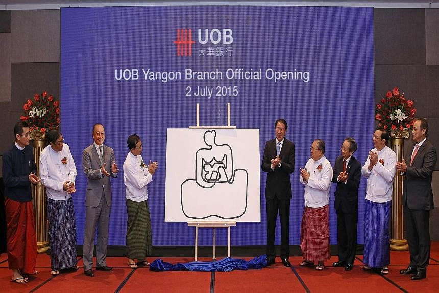 Unveiling a painting by Myanmar artist Aung Myint to mark the official opening of the UOB Yangon Branch yesterday were (from left) UOB Group chief executive officer Wee Ee Cheong; Ministry of Finance Union Minister Win Shein; Singapore Deputy Prime M