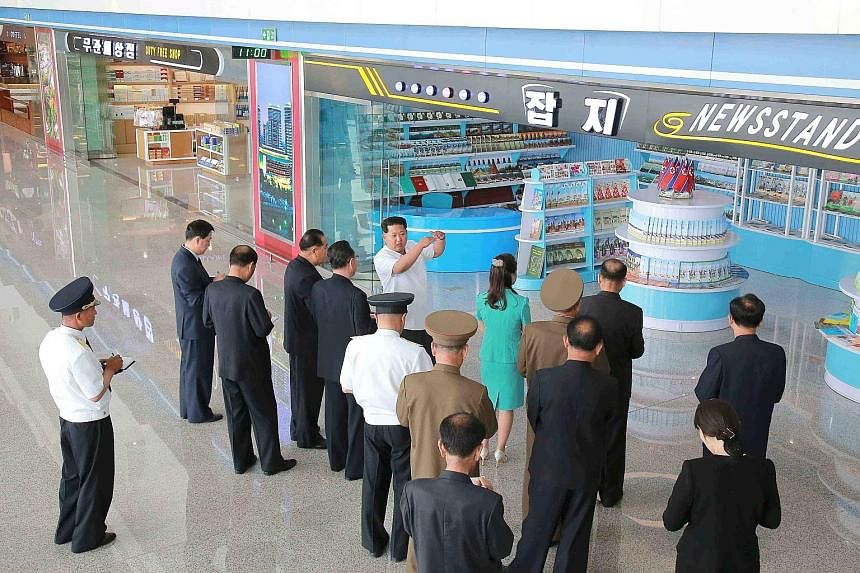 North Korean leader Kim Jong Un and his wife Ri Sol Ju (above) seen touring the facilities last month at Pyongyang's new airport (right).