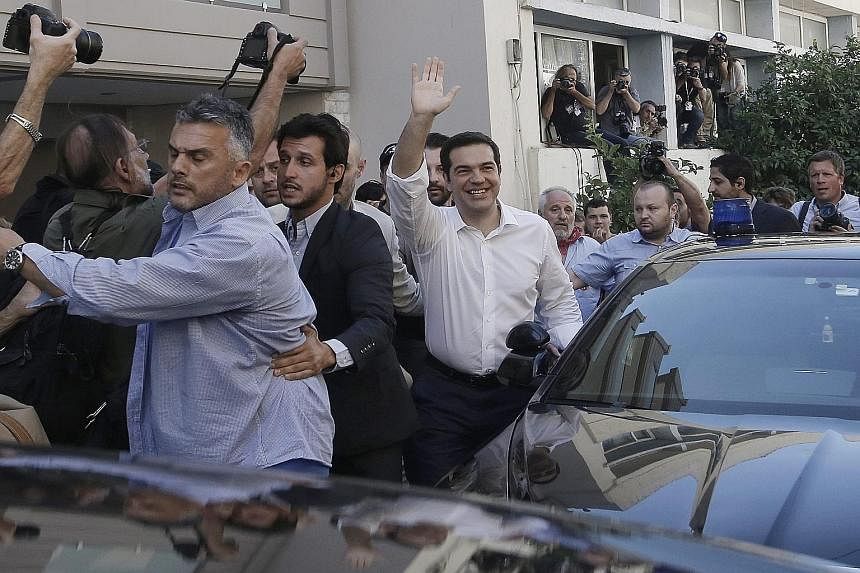 Greek PM Alexis Tsipras in high spirits after voting in Athens yesterday.