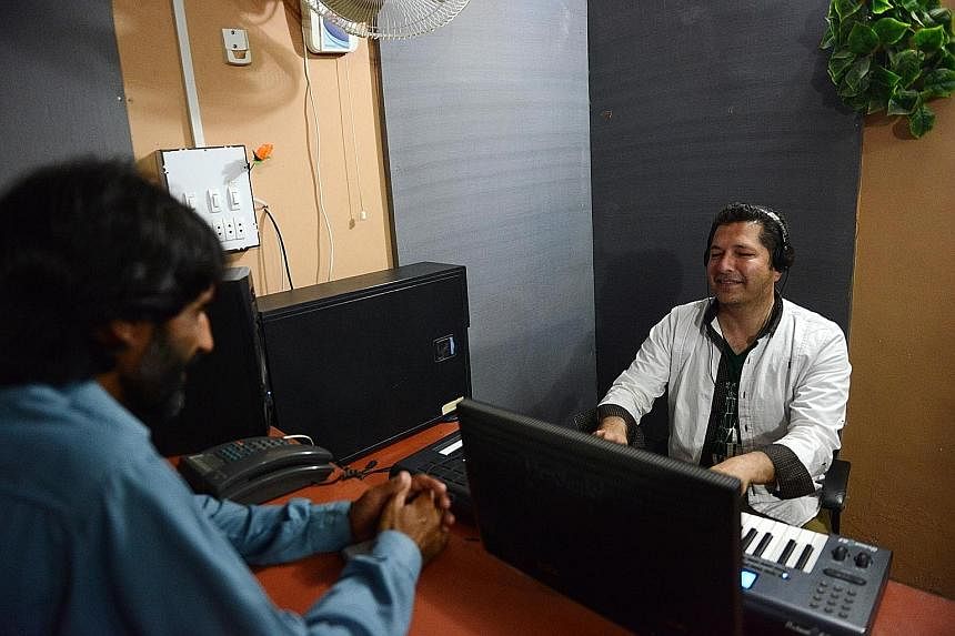 Pashto singer Bakhtiar Khattak (right) recording a song. The violence of Pakistan's bloody insurgency has been injected into catchy pop lyrics after over a decade of war against the Taleban.