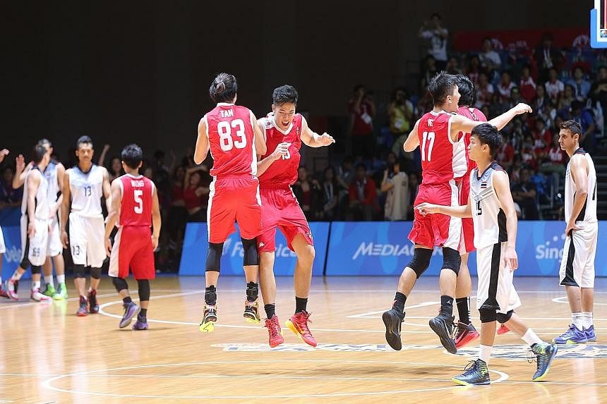 Singapore basketballers (in red), who are coached by Neo Beng Siang (right), chest-bumping each other after winning their second straight SEA Games bronze by beating Thailand.