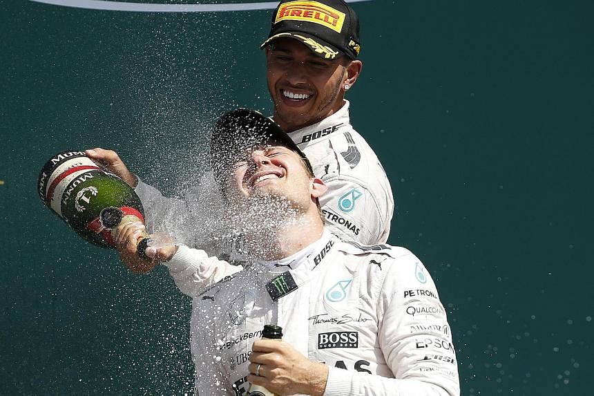 Having won yet another duel with his Mercedes team-mate and rival, Lewis Hamilton sprays champagne on Nico Rosberg as he celebrates his win on the podium.