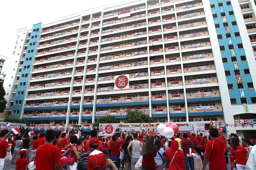 Sembawang residents gathered at Block 786B, Woodlands Drive 60, yesterday to unfurl more than a hundred national flags simultaneously from the block's corridors as they kicked off the "Fly our flag" campaign .